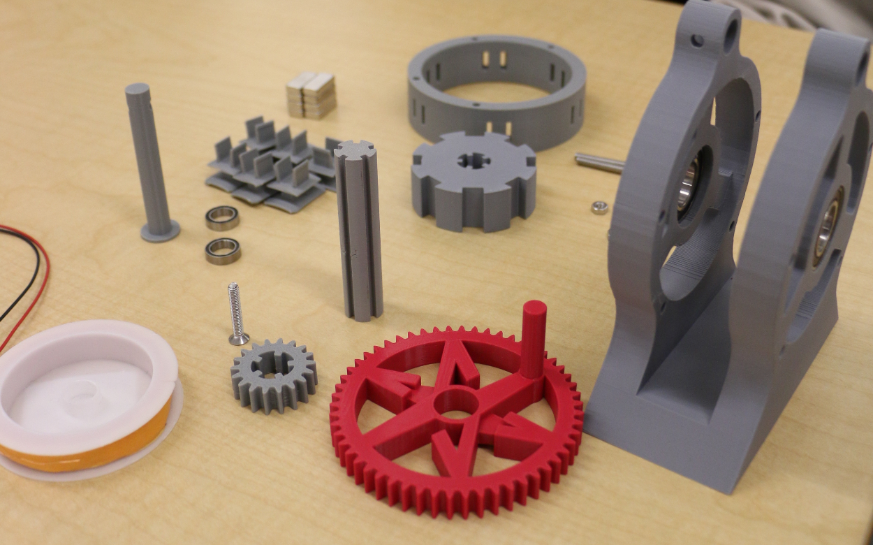 NextSpark: A full kit laid out before assembly: rotor, stator ring, coil holders, magnets, bearings, gears, casing halves and copper wire